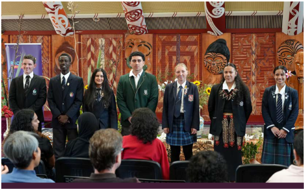 Image - Finalist students, standing infront of the stage and the audience